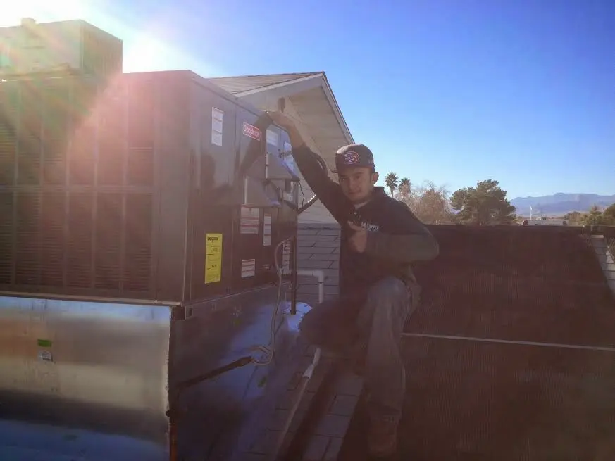HVAC technician performing AC Tune-Up on a rooftop unit in Broomfield